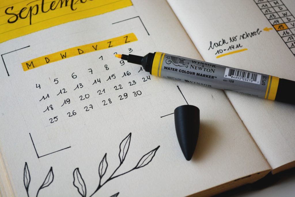 Picture illustrating someone writing in a planner to plan life